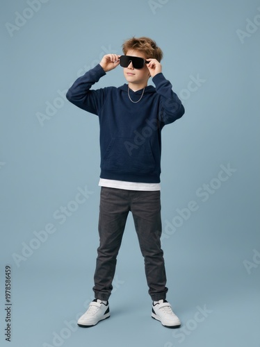 Stylish young boy posing in casual streetwear outfit.