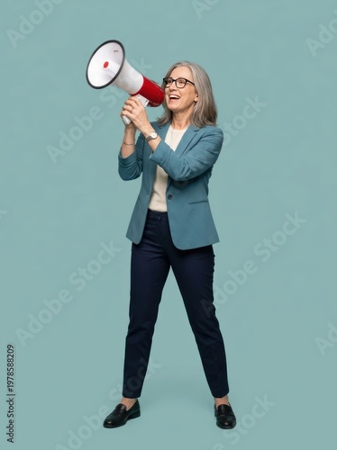 Smiling woman speaking into a megaphone against a plain background.