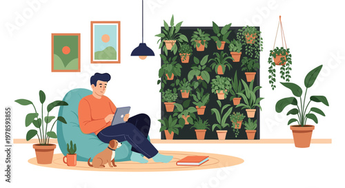 Young man sitting on a comfortable bean bag chair using a tablet in a cozy room decorated with a beautiful plant wall.