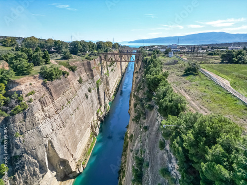 Bild auf Leinwand Aerial drone shot of Corinth Canal extending to distant sea horizon with surroun
