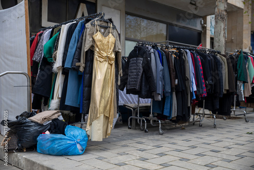 Quadro em tela Outdoor clothing rack with various second hand clothes on a city street