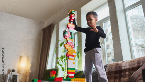 Obraz na płótnie Child stacking very tall tower of colorful blocks at home