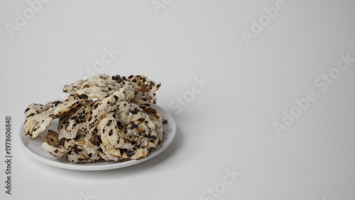 Tableau sur toile Tike chips or keripik tike, a traditional snack from Indramayu, Indonesia, made from nutgrass tubers, served on a white plate