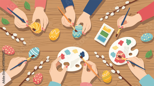 Overhead view of hands painting Easter eggs on a wooden table with watercolor palettes and willow branches in a cozy scene.