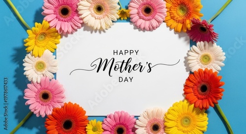 A colorful arrangement of flowers on a blue background, with a white card in the center that reads 'Happy Mother's Day'.