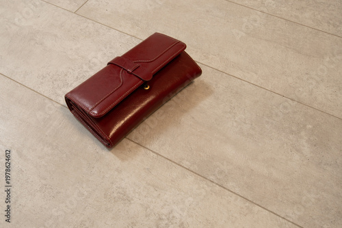 Wallet placed on a light-colored floor with a simple design, showing the details of the wallet and surroundings