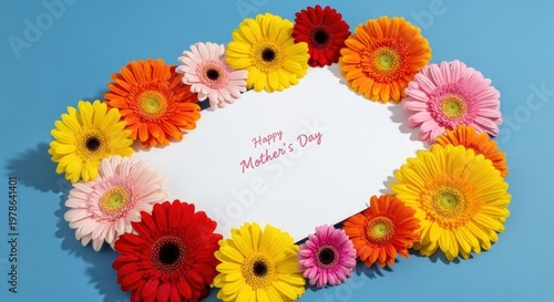 A colorful arrangement of flowers on a blue background, with a white card that says 'Happy Mother's Day'
