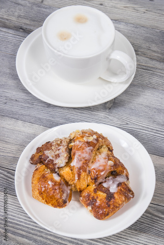 Traditional croissants with poppy seed filling and cup of coffee with milk. Dessert from polish city Poznan. Martin's croissant