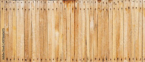 Background texture of light brown wooden planks arranged vertically with visible nail heads and natural woodgrain