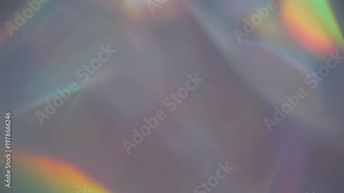 Rainbow light prism refraction patterns dancing gracefully across a smooth neutral wall surface in motion video clip