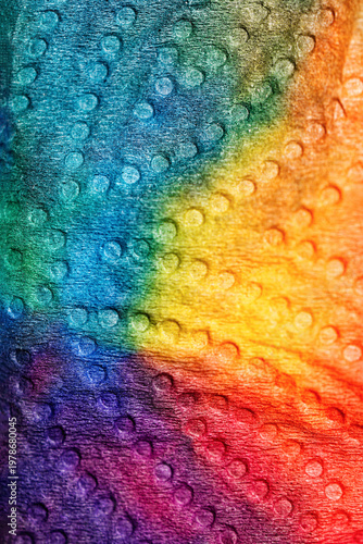 Abstract background featuring a bumpy, embossed texture with a smooth rainbow color gradient