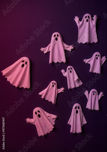 Colorful paper ghosts floating on purple background for Halloween  