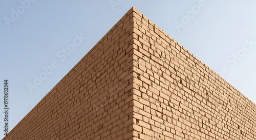 A low-angle shot captures the sharp corner and rough stone texture of an ancient pyramid.