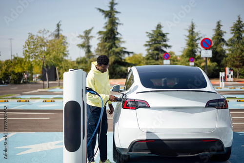 Man charging electric car at public station
