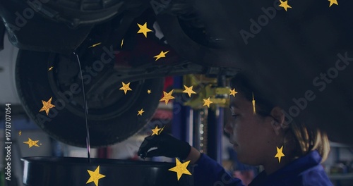 Working mechanic blue-coverall black-glove draining oil from plug into drum below lift, copy space