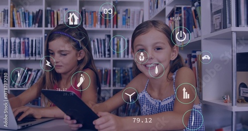 Smiling girls holding tablet and typing laptop among library bookshelves, one in checkered top, HUD