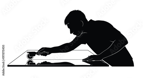 Silhouette of a man cutting a piece of paper with scissors on a table