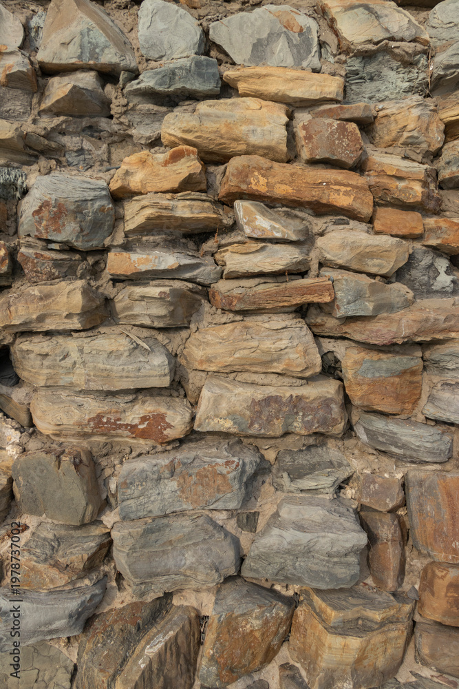 Fototapeta premium Beige stone wall forming an outdoor textured background surface