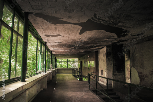 Foto Abandoned interior with large windows and deteriorated ceiling