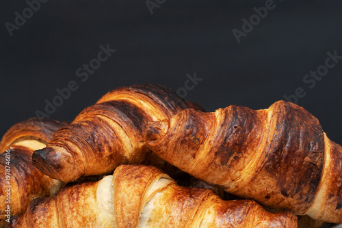 Freshly baked croissants close up on black background