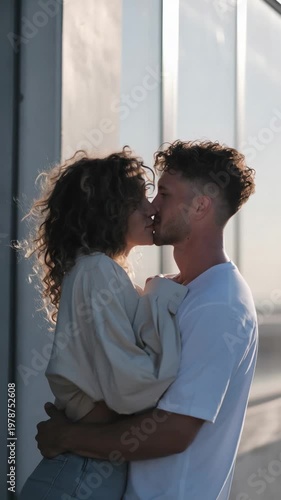 Couple enjoys a moment together during sunset at a rooftop location in the city