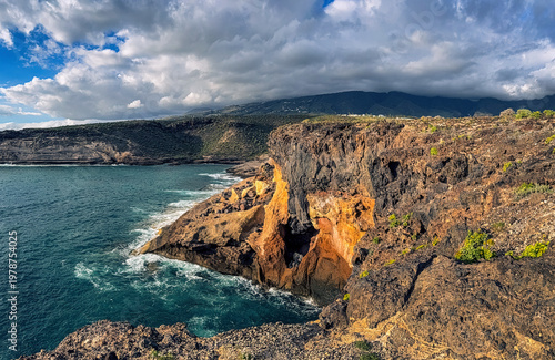 Colorful volcanic cliffs and turquoise ocean in La Caleta Tenerife Canary Islands