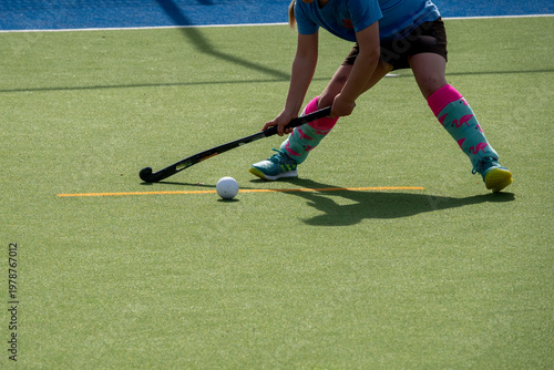 Young Field Hockey Player Controlling Ball On Green Artificial Turf With Colorful Socks