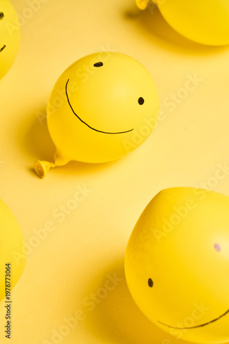 Happy Yellow Day Symbol with Smiling Face Balloon and Text on Yellow Surface