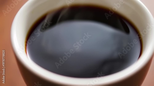 Close-up of a steaming cup of dark coffee