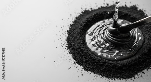 Dark Liquid Pouring into a Pile of Black Powder on a White Background.