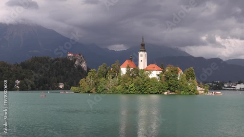 lake bled island church reflection with castle on mountain cliff background (famous european travel tourism destination in julian alps) slovenia europe scenic landscape sunset glow boat rowing nature