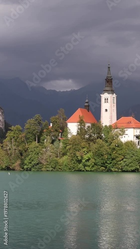 lake bled island church reflection with castle on mountain cliff background (famous european travel tourism destination in julian alps) slovenia europe scenic landscape sunset glow boat rowing nature