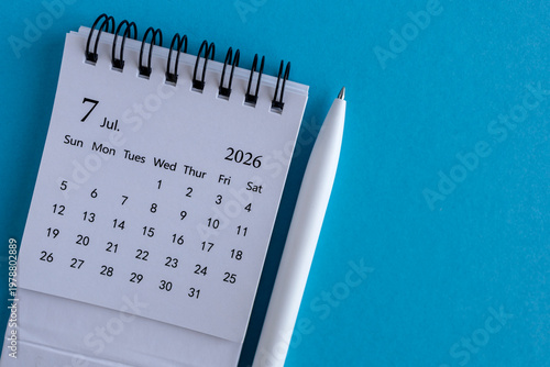 Desk calendar for July 2026 on a blue background with space for notes.