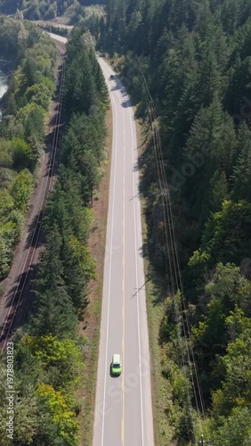 Aerial View of Cars Driving on a Winding Road Through a Lush Forest in British Columbia, Canada