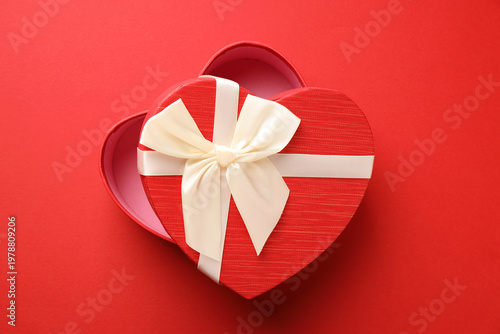 Beautiful heart shaped box on red background, top view