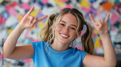 Girl Making Hand Signs in Front of Colorful Wall During Daytime