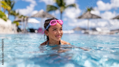 Woman Swims in a Clear Pool Surrounded by Palm Trees at a Tropical Resort Dur...