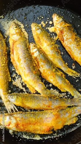 Cooking fresh fish fried BBQ with delicious crispy golden crust in cast-iron pan over an open fire. Cooking outdoors, such as camping, and for those who enjoy preparing meals in natural surroundings
