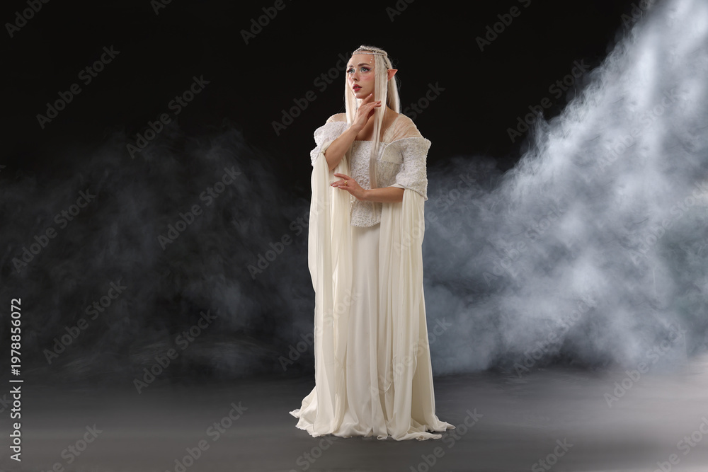 Naklejka premium Beautiful girl dressed as elf on black background with smoke