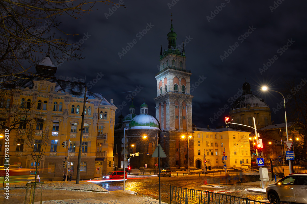 Fototapeta premium night time scene city street with church tower buildings road traffic long exposure Europe district historical view