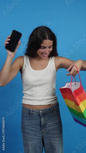 Young woman promoting online shopping with rainbow bag