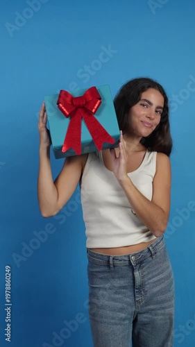 Happy woman dancing with a birthday gift box