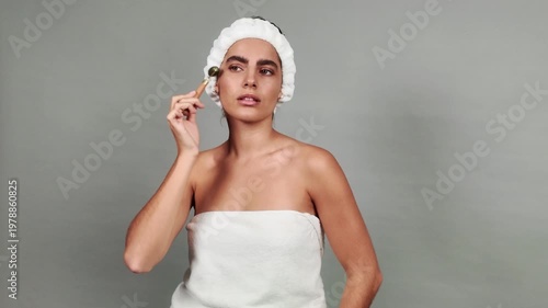 Beautiful woman performing a face massage with a jade roller