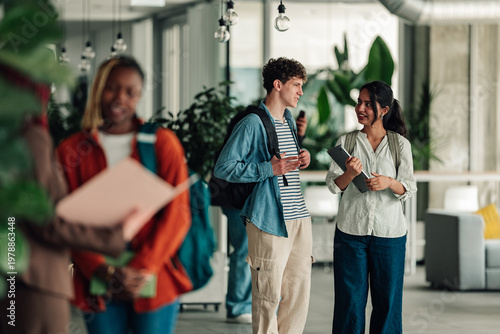 Εκτύπωση καμβά Diverse students walking and communicating in modern campus building, discussing