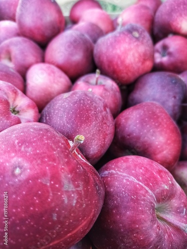 A close-up, high-angle shot focusing on a cluster of ripe, deep red apples.