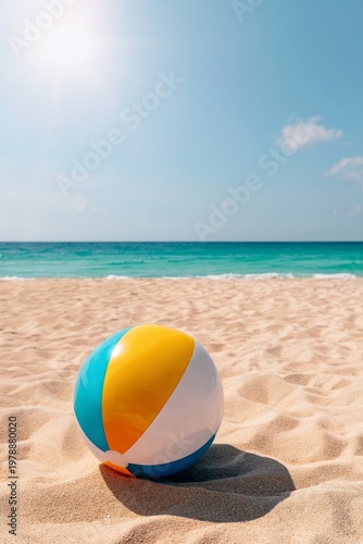Beach Ball Sits on Sand Under Bright Sun by the Ocean During a Clear Day