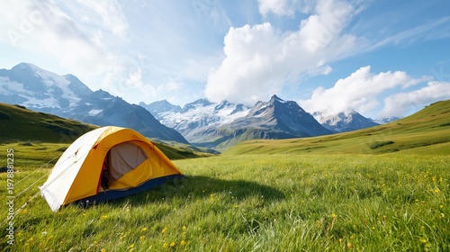 Camping in a Mountain Landscape With a Tent Set up in Open Grass Under a Blue...