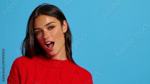 Model Poses in Red Sweater Against Blue Background in Studio Setting