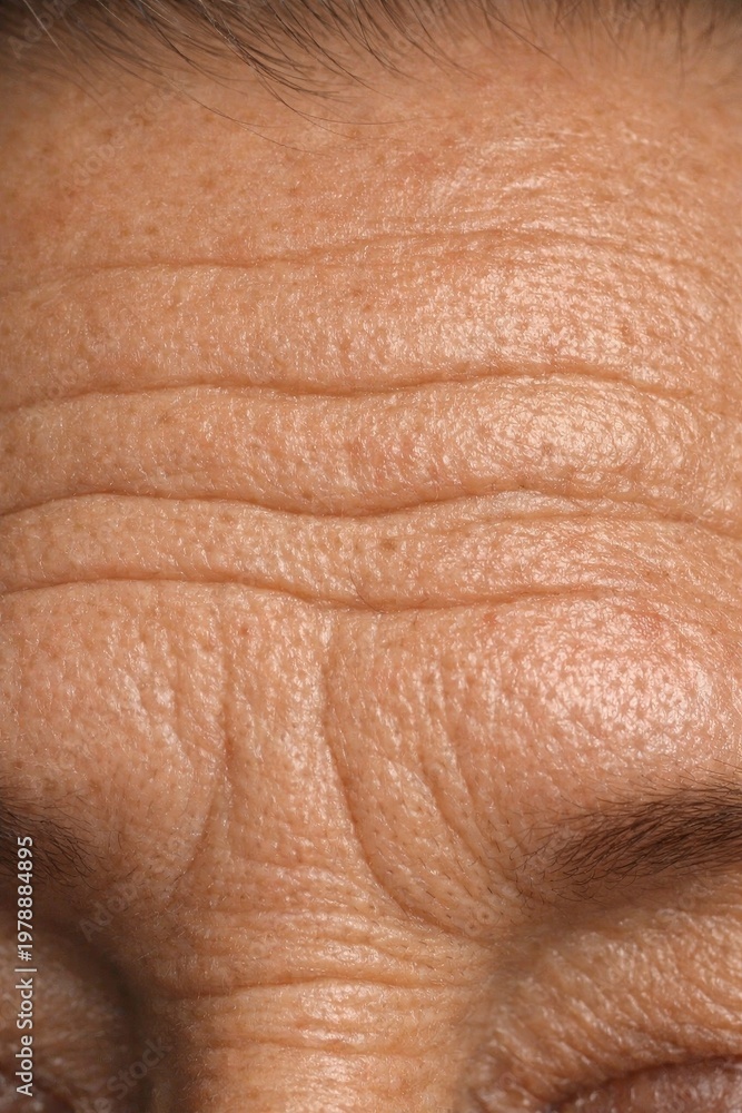 Fototapeta premium Close-up of aged skin texture with visible wrinkles. Natural lighting enhances details and authenticity. Ideal for health and beauty concepts. Vertical image emphasizes skin condition.