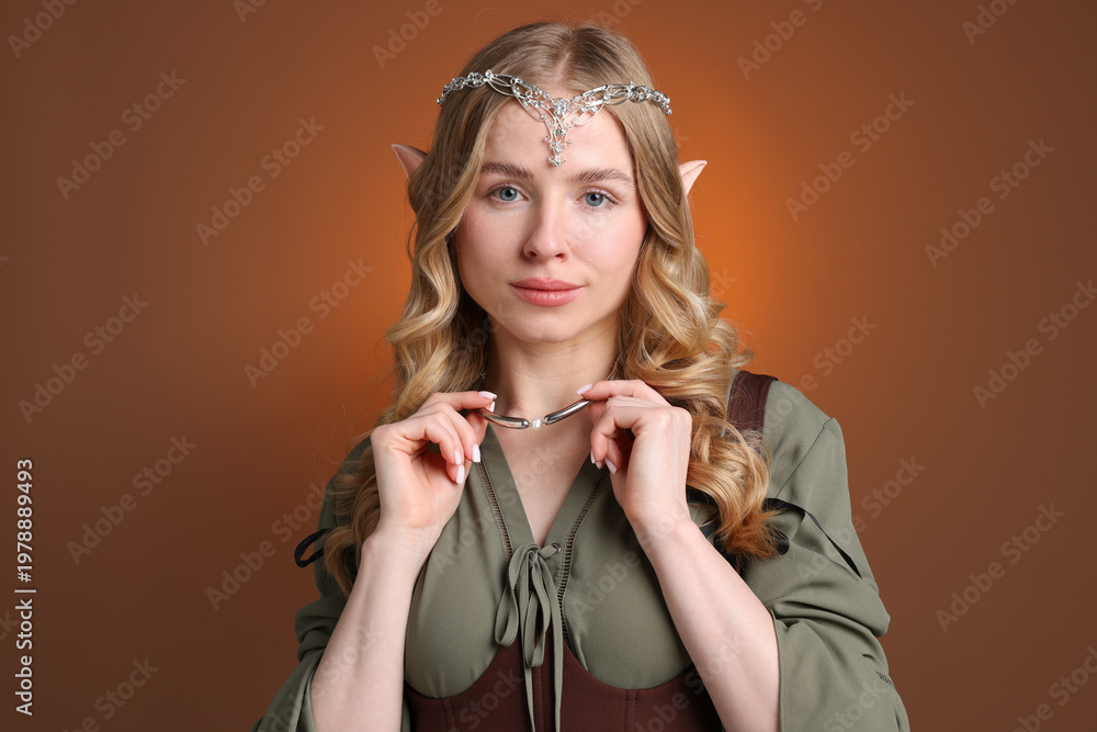 Naklejka premium Beautiful girl dressed as elf on brown gradient background